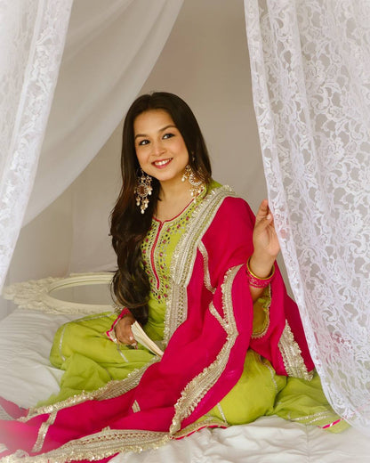 Vibrant lime green traditional outfit with pink and gold accents.